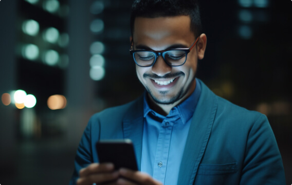 Homem sorrindo olhando para celular